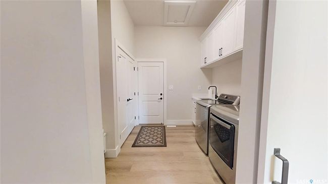 Laundry area with washer and clothes dryer, cabinet space, and light wood-style flooring | Image 15