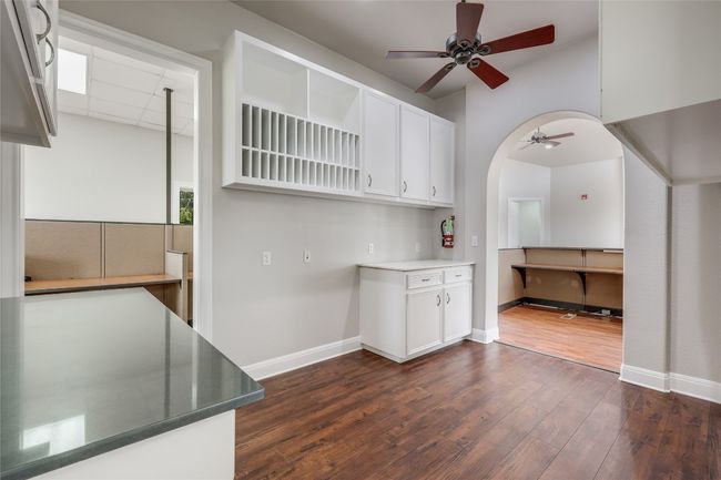 Kitchen with dark wood finished floors, white cabinets, baseboards, and a ceiling fan | Image 26