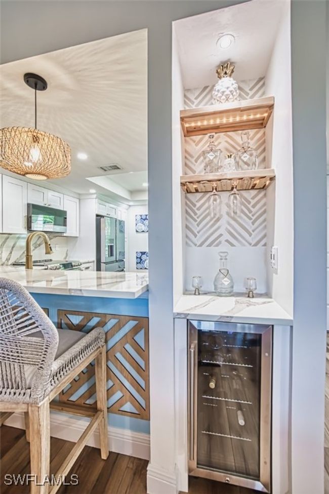 Indoor dry bar featuring wine cooler, wood finished floors, stainless steel appliances, pendant lighting, and recessed lighting | Image 14