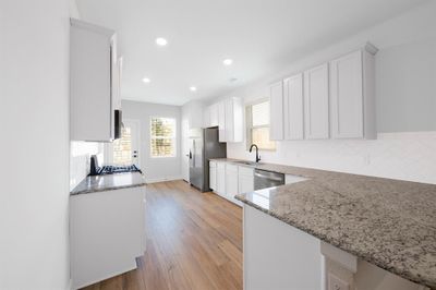 You will love the polished granite countertops, 42" white upper wood cabinetry, and a full suite of stainless-steel Whirlpool kitchen appliances. | Image 2