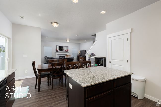 Kitchen featuring a fireplace, dark wood-style floors, baseboards, a center island, and recessed lighting | Image 13