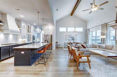 The shared living spaces promote unity and functionality! The high vaulted ceiling has large beam that adds character to the space. | Image 1