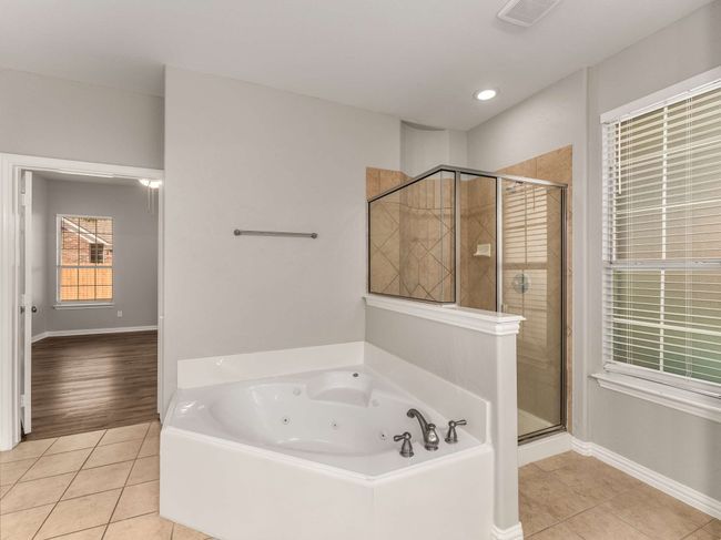 Bathroom with visible vents, a stall shower, a tub with jets, tile patterned flooring, and baseboards | Image 18