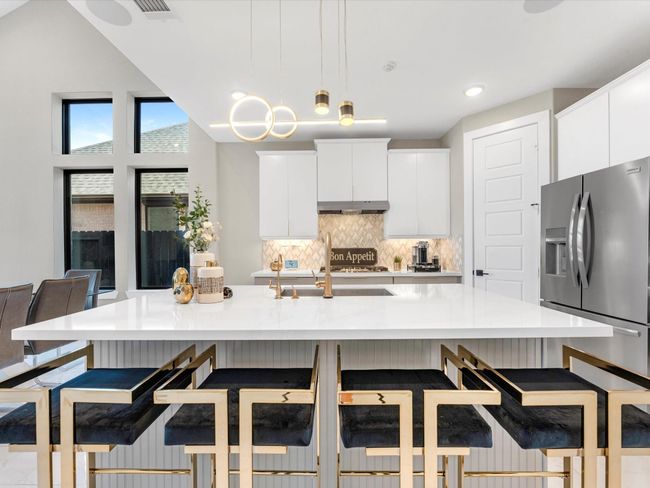 Seamlessly combining modern and functionality, the kitchen showcase a spacious island with a sleek countertops and upgrades undercabinet lighting, sliding doors custom faucet, upgraded stainless steel appliances and state of the art water filtration. | Image 6