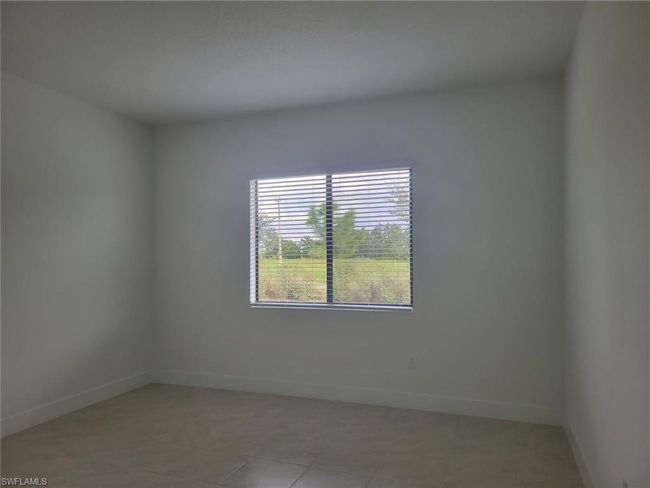 Empty room with baseboards and light tile patterned floors | Image 8