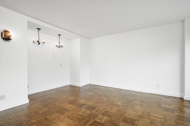 Spare room with a chandelier and baseboards | Image 4