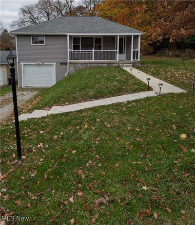 View of front of house with a front yard, a porch, and a garage | Image 2