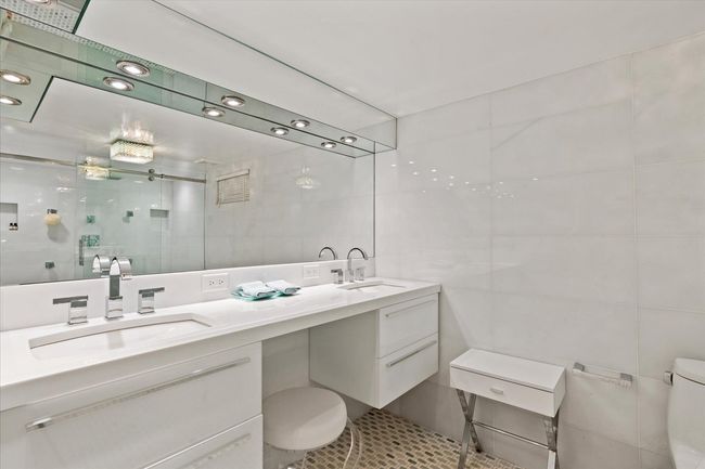 Full bath with tile walls, double vanity, a stall shower, and tile patterned floors | Image 21