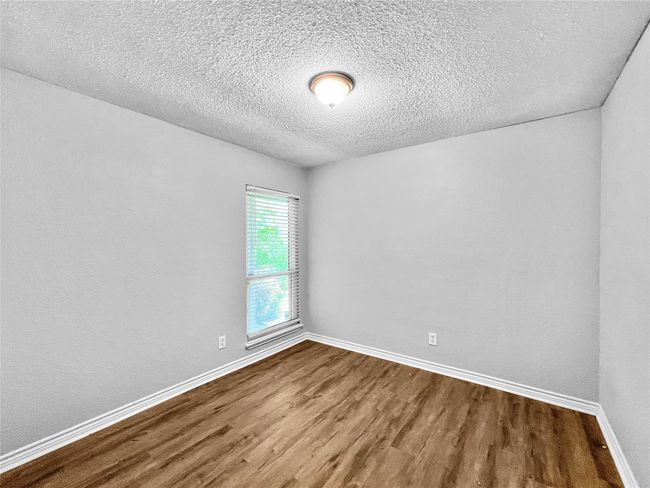Unfurnished room with dark wood finished floors and a textured ceiling | Image 11