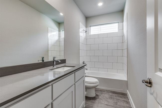 Full bathroom with hardwood / wood-style flooring, tiled shower / bath combo, vanity, and toilet | Image 16