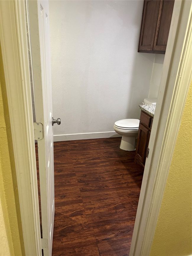 Bathroom featuring wood finished floors, a textured wall, and vanity | Image 11
