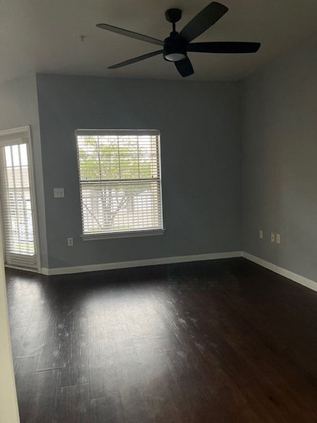 Spare room with a ceiling fan, baseboards, and dark wood-style flooring | Image 23