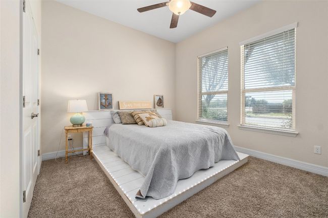 Bedroom with a ceiling fan, carpet floors, and baseboards | Image 22