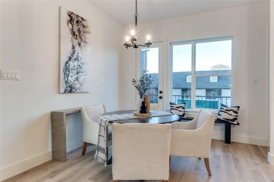 Dining space with a notable chandelier and light hardwood / wood-style floors | Image 3