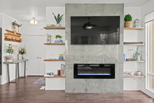 Living room featuring a tiled fireplace and wood finished floors | Image 7
