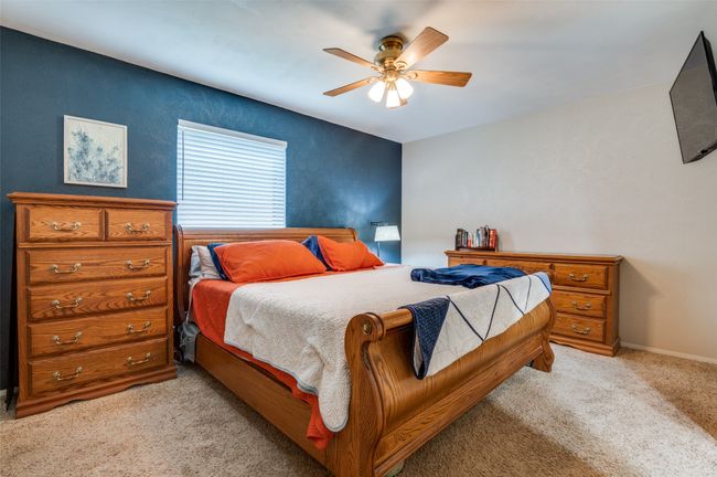 Bedroom with light colored carpet and a ceiling fan | Image 15