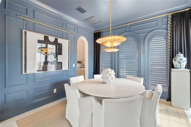 Dining area with a decorative wall, visible vents, and arched walkways | Image 17