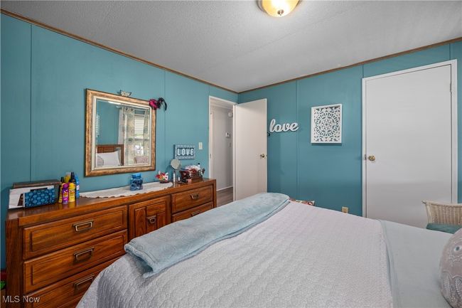 Bedroom featuring a decorative wall and crown molding | Image 32