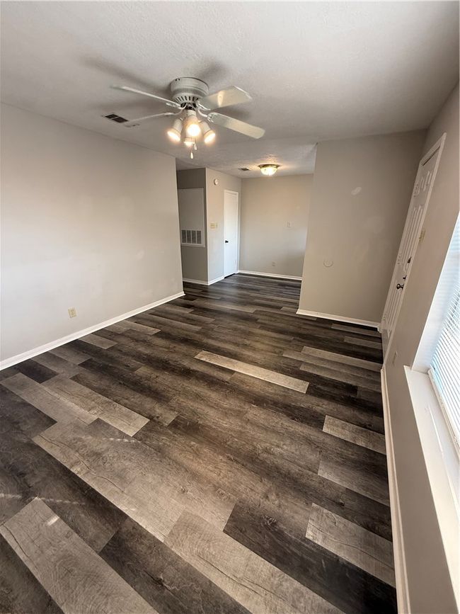 Unfurnished room with dark wood-style floors, ceiling fan, and a textured ceiling | Image 5