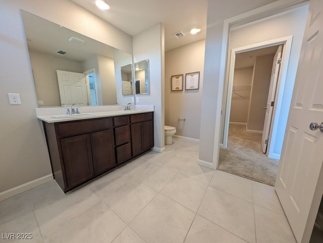Bathroom with double vanity, a walk in closet, and tile patterned flooring | Image 23