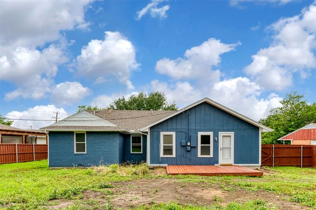 Rear view of property with a deck, a shingled roof, and brick siding | Image 34