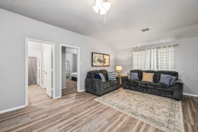 Living area with visible vents, baseboards, vaulted ceiling, and wood finished floors | Image 29
