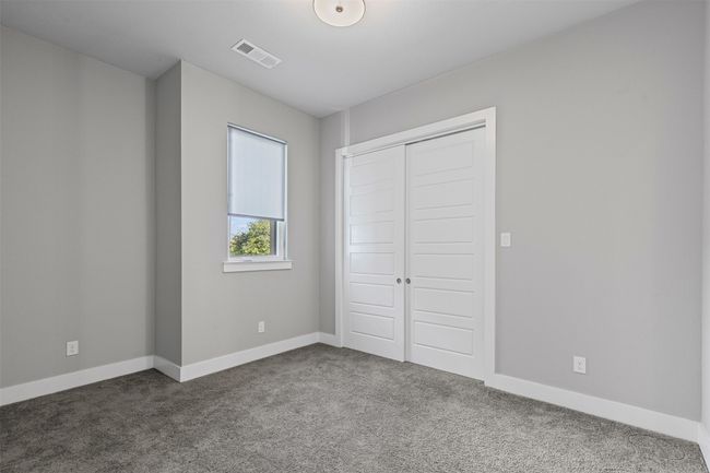 Unfurnished bedroom featuring dark colored carpet, baseboards, and a closet | Image 15