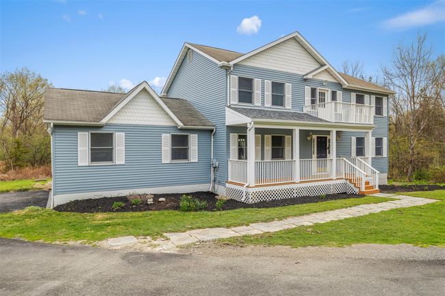 View of front of home featuring roof with shingles, a porch, a front lawn, and a balcony | Image 34