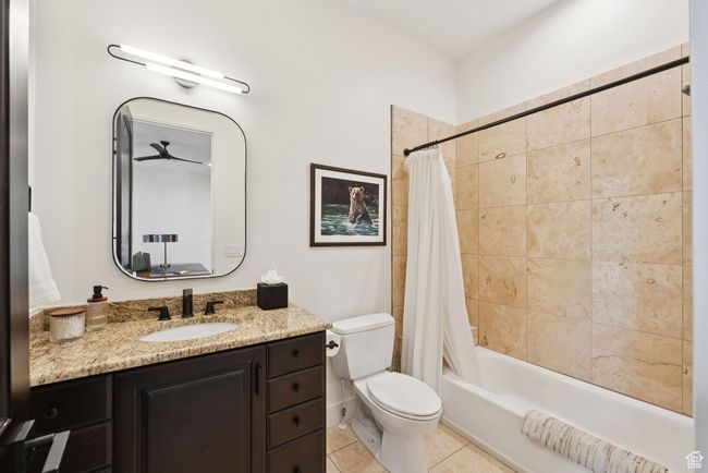 Bathroom featuring shower / bath combo with shower curtain, vanity, and tile patterned floors | Image 74