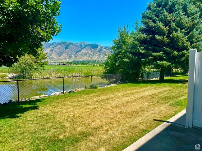 View of yard right off of patio with a water and mountain view | Image 14