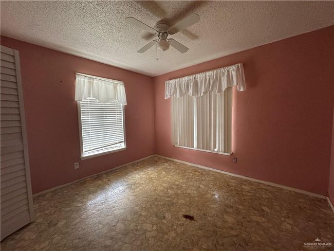 Spare room with a ceiling fan, a textured ceiling, and baseboards | Image 10