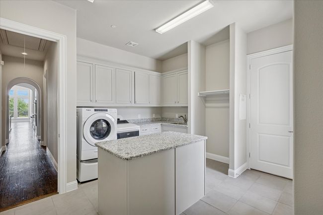 Large utility room with mud room and lots of cabinets for storage | Image 36