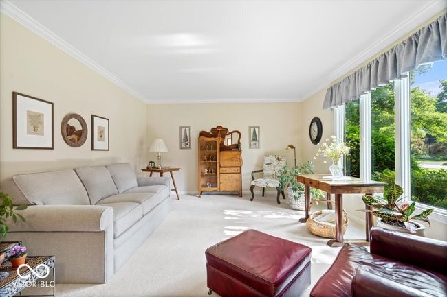 living room featuring crown molding, healthy amount of natural light, and carpet flooring | Image 5