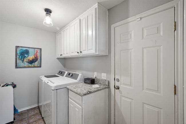 Washroom with washing machine and dryer, baseboards, and cabinet space | Image 13