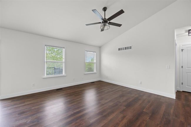 Empty room featuring ceiling fan, visible vents, dark wood-style floors, and baseboards | Image 23