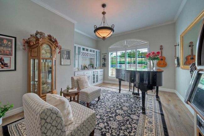 Living area with baseboards, wood finished floors, and ornamental molding | Image 6