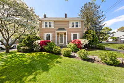 Curb appeal for days!! This vintage colonial looks like the front of a New England postcard, with timeless exterior, stone front portico, beautiful gardens, and paver walkway dotted with greenery. | Image 1