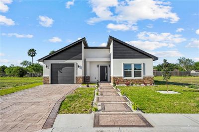 View of front of property featuring a front yard and a garage | Image 1