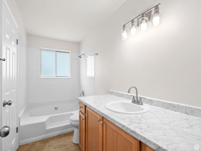 Full bath featuring vanity, toilet, washtub / shower combination, and tile patterned flooring | Image 16