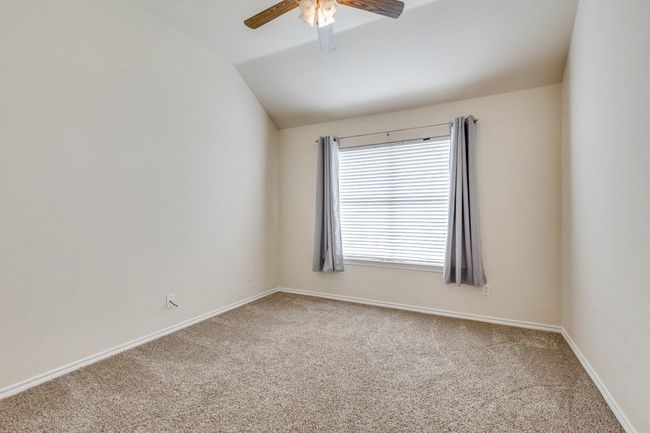 Carpeted spare room featuring baseboards, lofted ceiling, and ceiling fan | Image 20