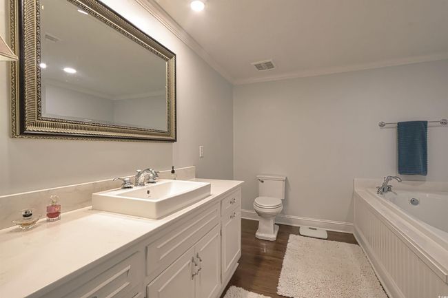 Bathroom with vanity, a garden tub, ornamental molding, and wood finished floors | Image 12