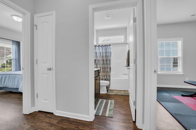 Corridor with dark wood-type flooring, plenty of natural light, and visible vents | Image 15