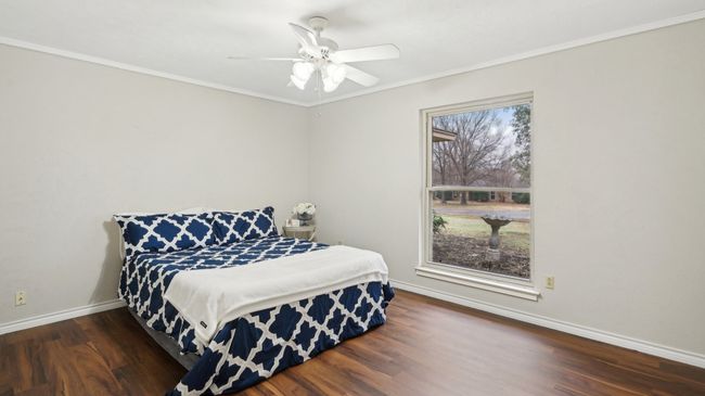 Bedroom featuring baseboards, ceiling fan, crown molding, and dark wood-style flooring | Image 18