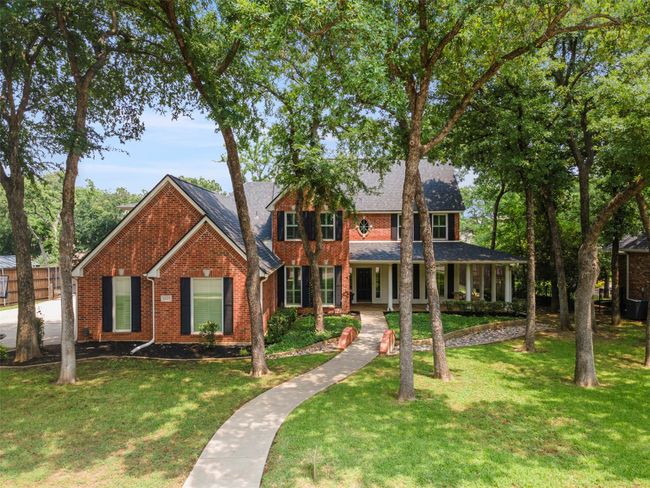View of front facade featuring brick siding, a front lawn, a porch, and roof with shingles | Image 12