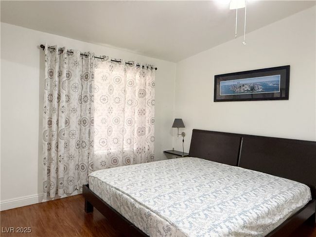 Bedroom featuring lofted ceiling, baseboards, and wood finished floors | Image 23