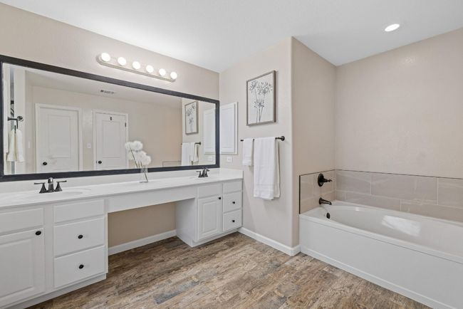 The beautifully remodeled en-suite bathroom features an expansive dual vanity and a soaking tub that’s perfect for unwinding. | Image 19