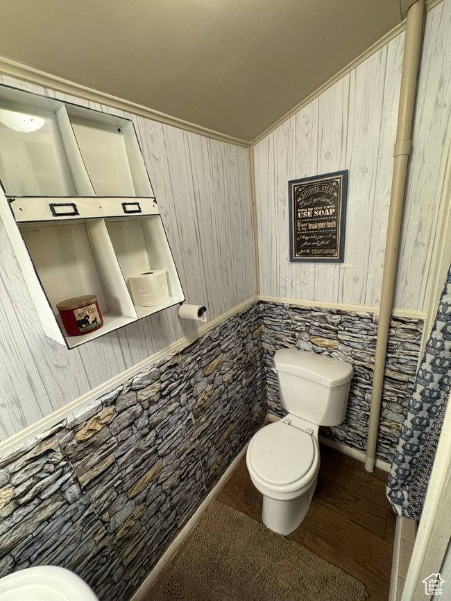 Half bath with wood finished floors and wood walls | Image 10