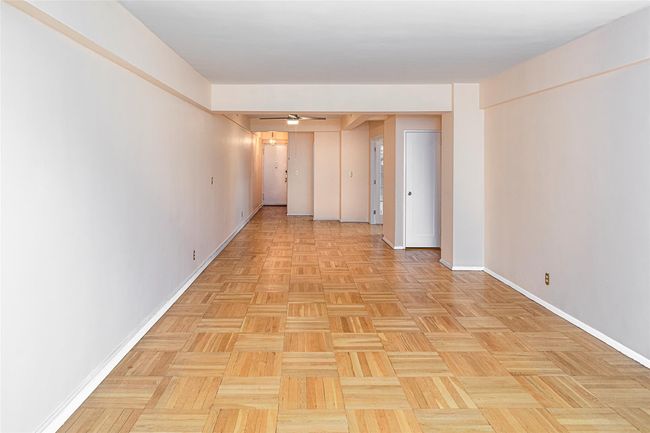View of the foyer and living room as taken from the windowed wall of the living room. | Image 7