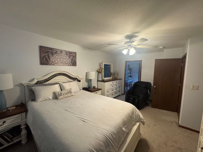 Bedroom with light colored carpet, a ceiling fan, and a textured ceiling | Image 20