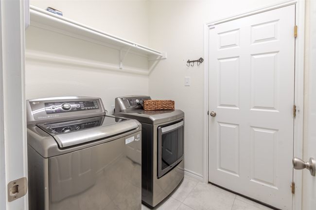 Laundry area featuring laundry area, independent washer and dryer, and light tile patterned flooring | Image 14